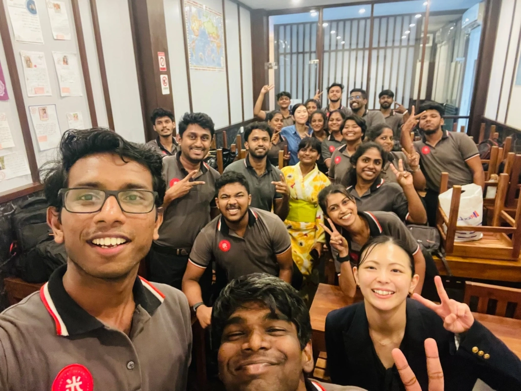 多くの若い男女が笑顔でポーズをとっている集合写真