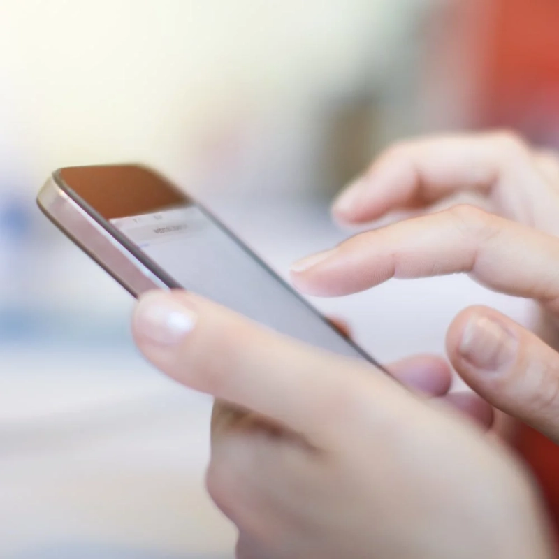 スマートフォンを操作している手がクローズアップで写っています。