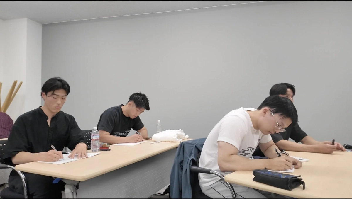 机に向かって勉強する若者たち