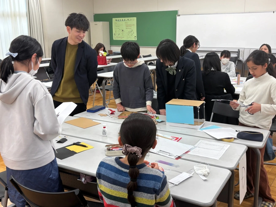 教室で紙や段ボールを使ってものづくりやクラフト作業を行っている生徒たち