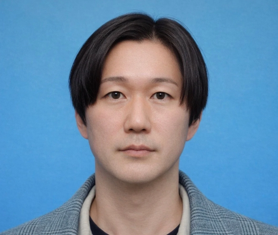 青い背景の前に立つアジア人男性のポートレート。