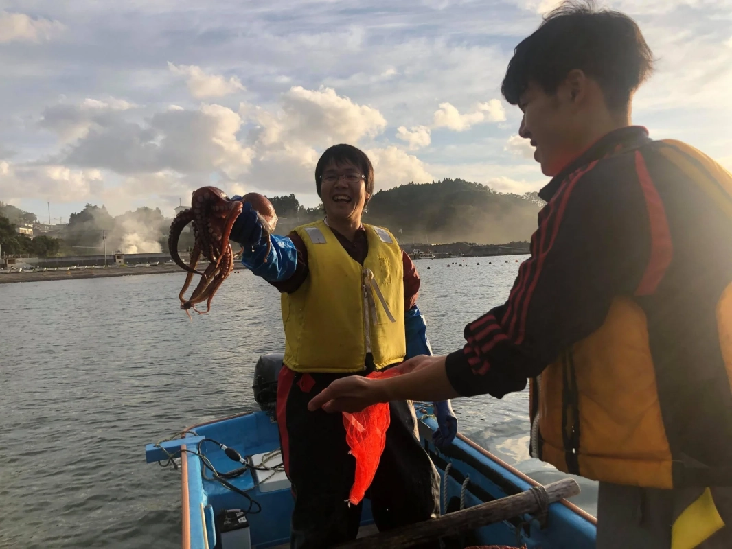 タコを抱える笑顔の人々