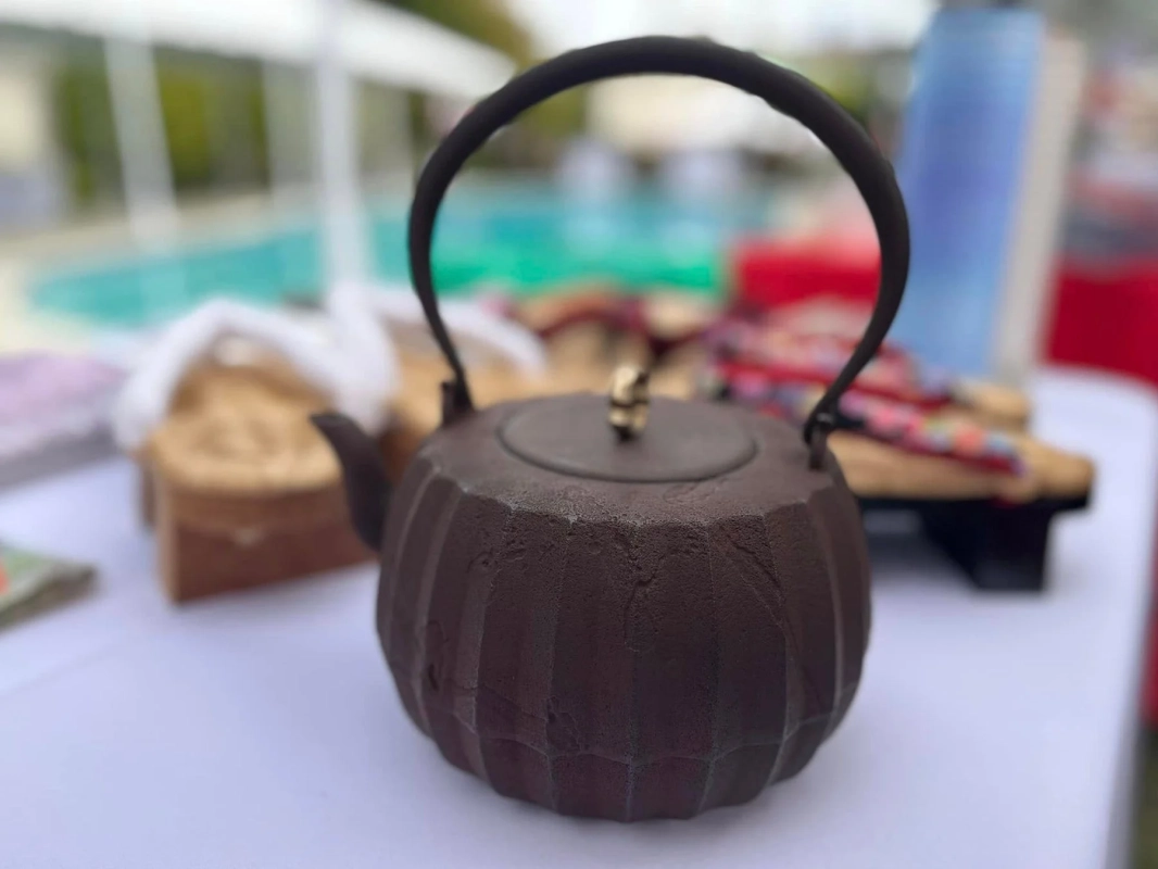 屋外のテーブルに置かれた、日本の伝統的な鉄瓶のクローズアップ画像