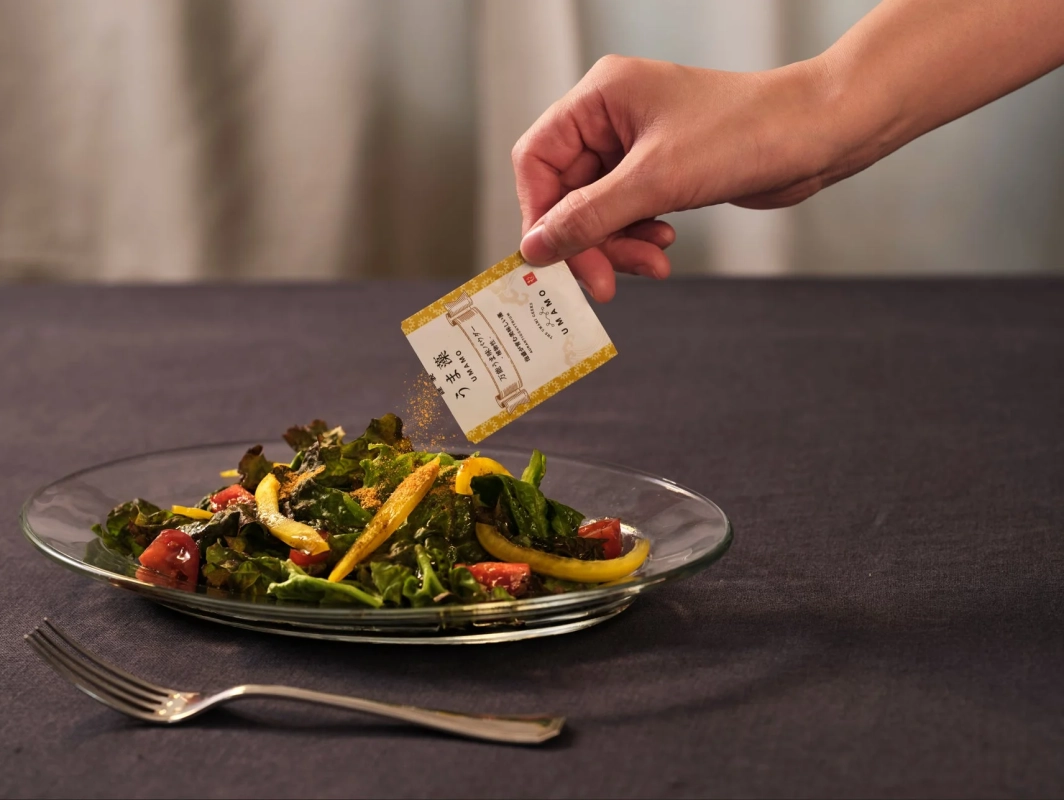 サラダにうま藻パウダーをかける様子