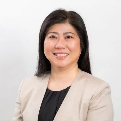 ベージュのジャケットと黒いブラウスを着て微笑むアジア人女性のポートレート