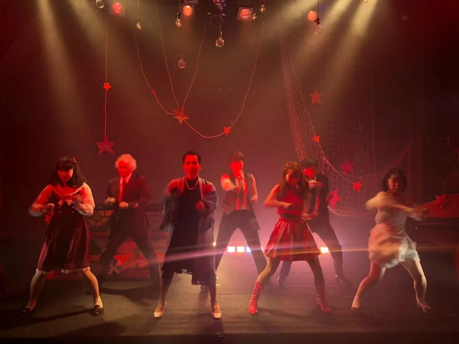 赤い照明の中でダンスを披露するパフォーマー