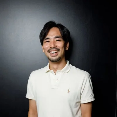 白いポロシャツを着て笑顔を見せるアジア人男性のポートレート