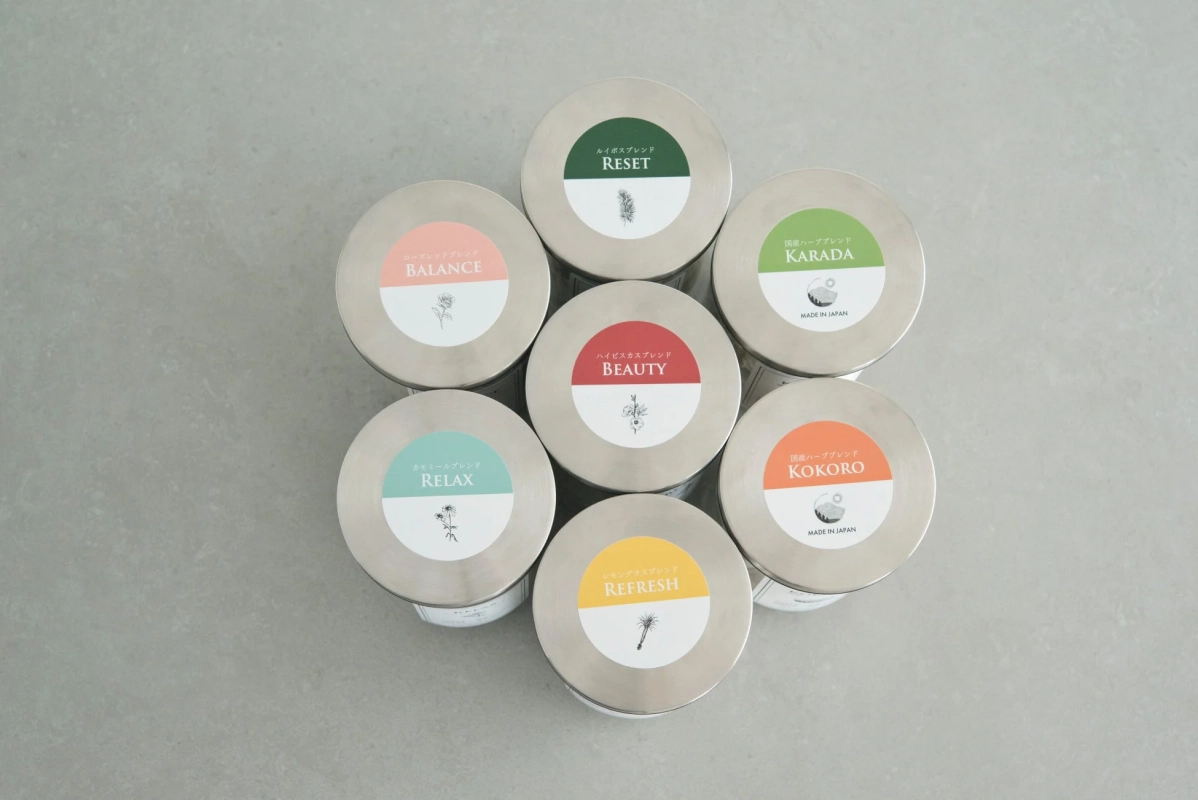 様々な種類のハーブブレンドが入った円形の缶が、規則的に並べられています。